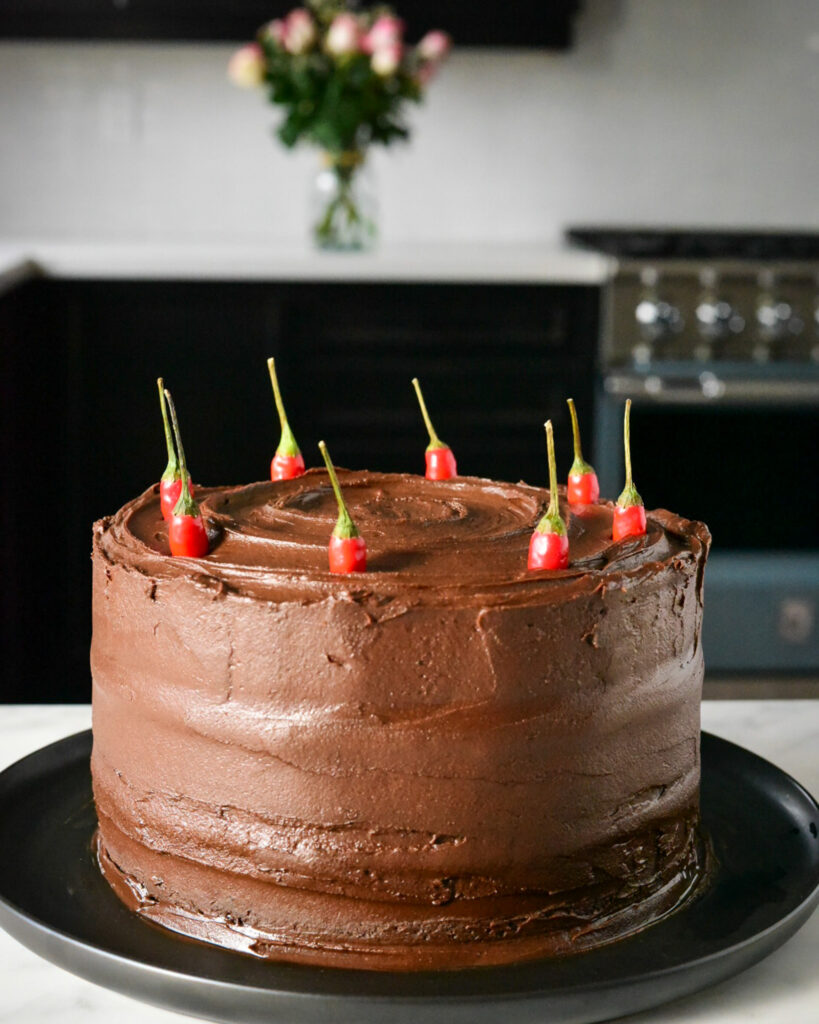 A three layer spicy chocolate cake decorated with fresh chilies.
