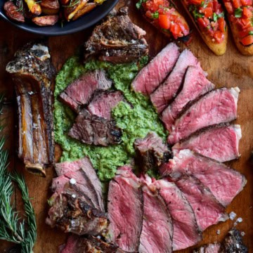 Florentine-Style Steak served with salsa verde, crispy potatoes (cooked in the beef fat trimmings) and bruschetta.