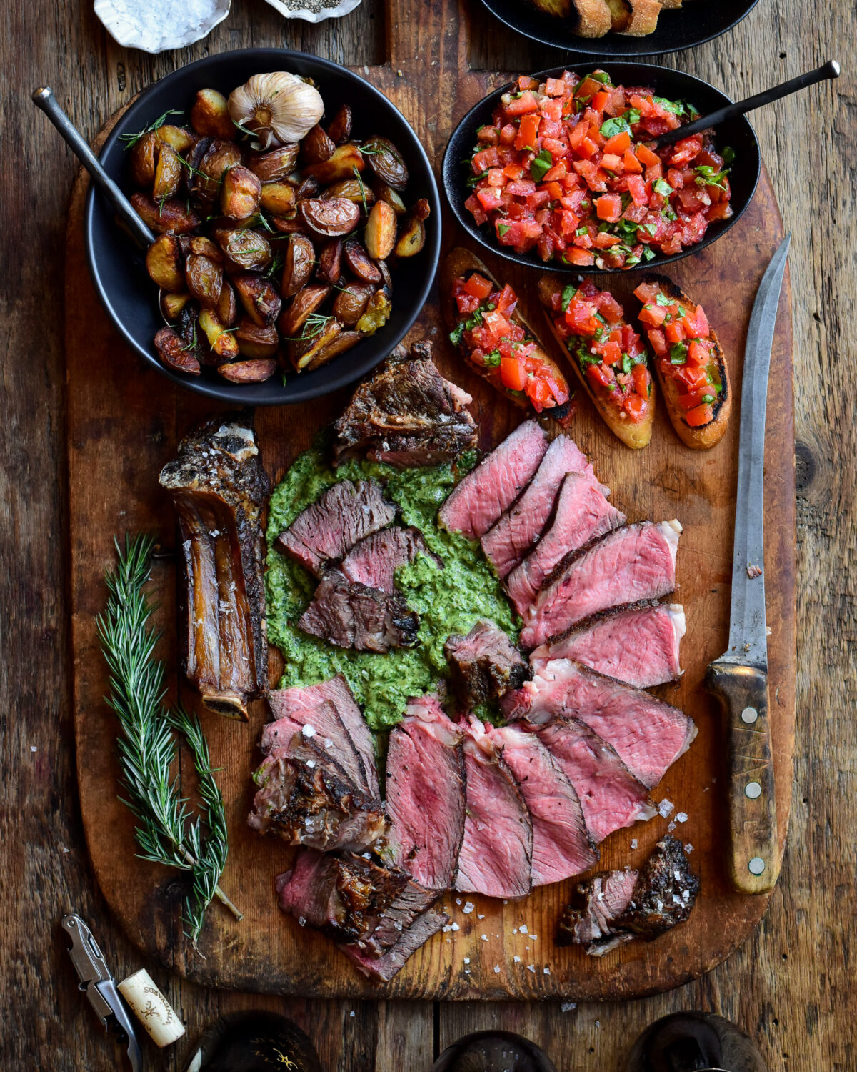 Florentine-Style Steak served with salsa verde, crispy potatoes (cooked in the beef fat trimmings) and bruschetta.