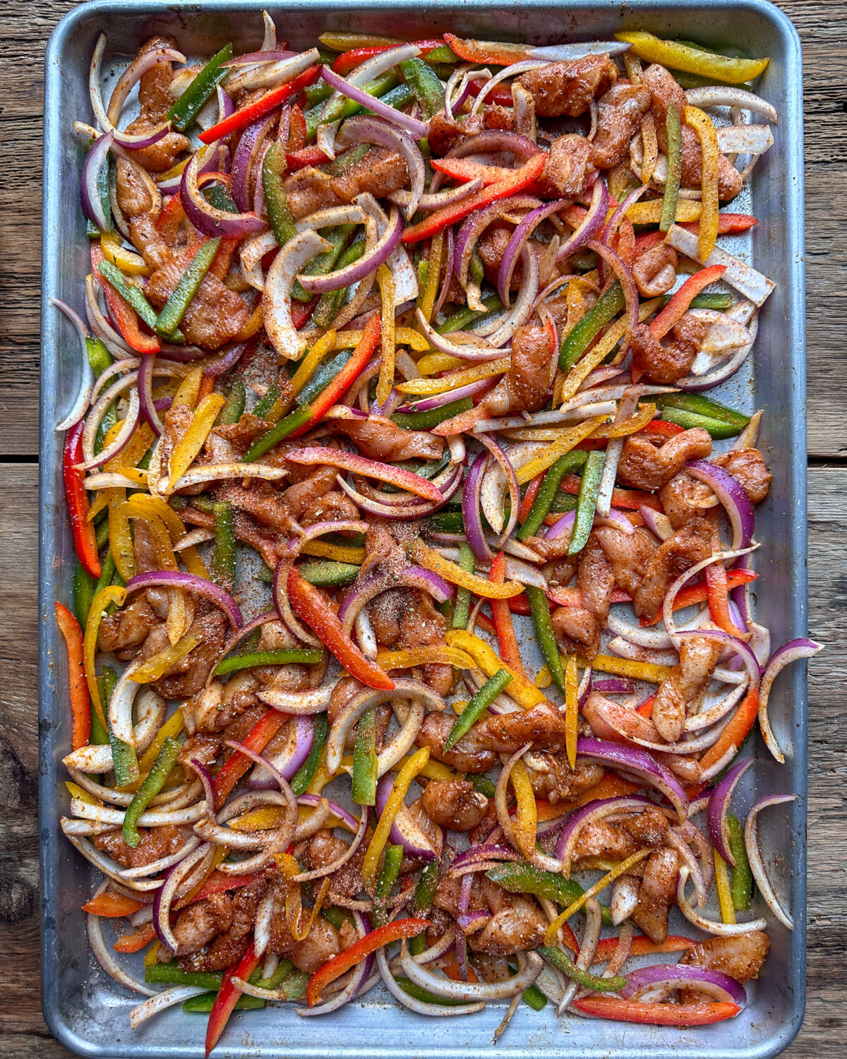 Spread the chicken and vegetables in an even layer across the sheet pan. 