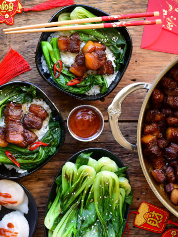 Two bowls of Chinese style braised pork belly served with steamed rice and vegetables.