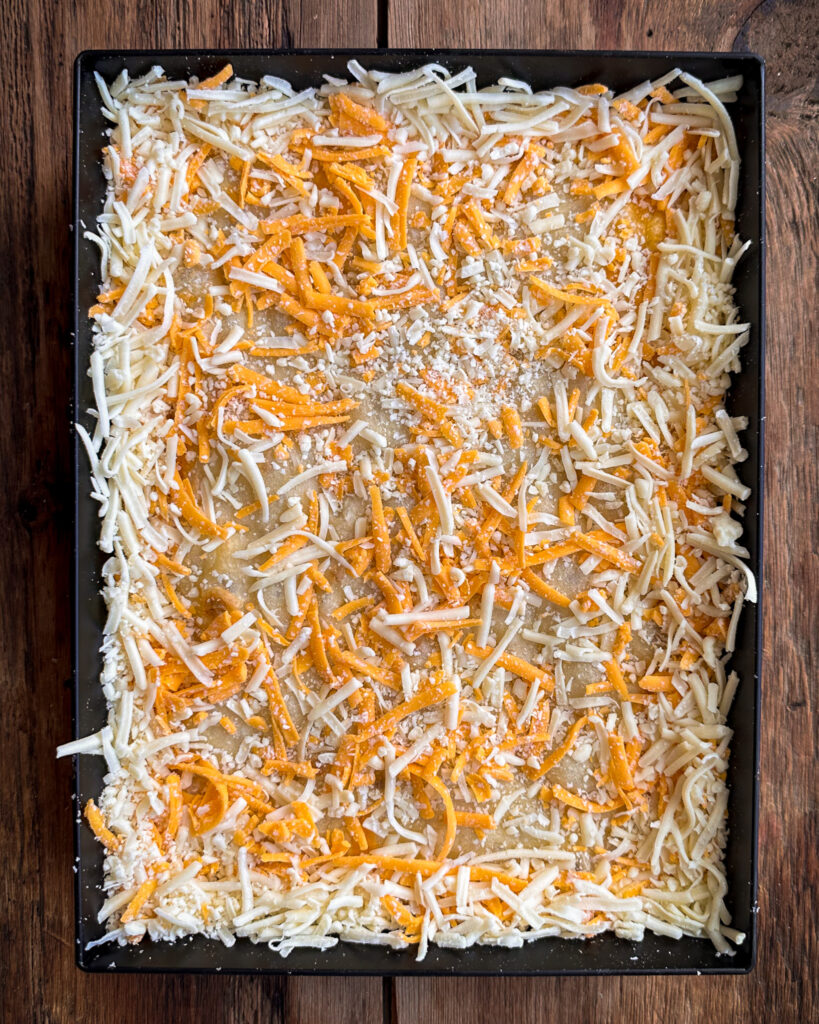 A 3-cheese blend of shredded cheese placed on the DSP pizza.