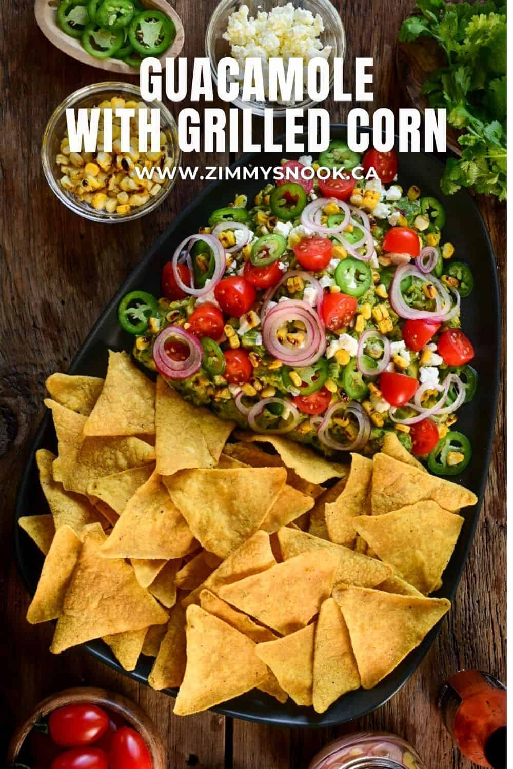 A platter of Guacamole with Grilled Corn and chips.
