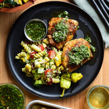 Two Chicken Thighs made in the air fryer and served chimichurri and a BLT pasta salad.