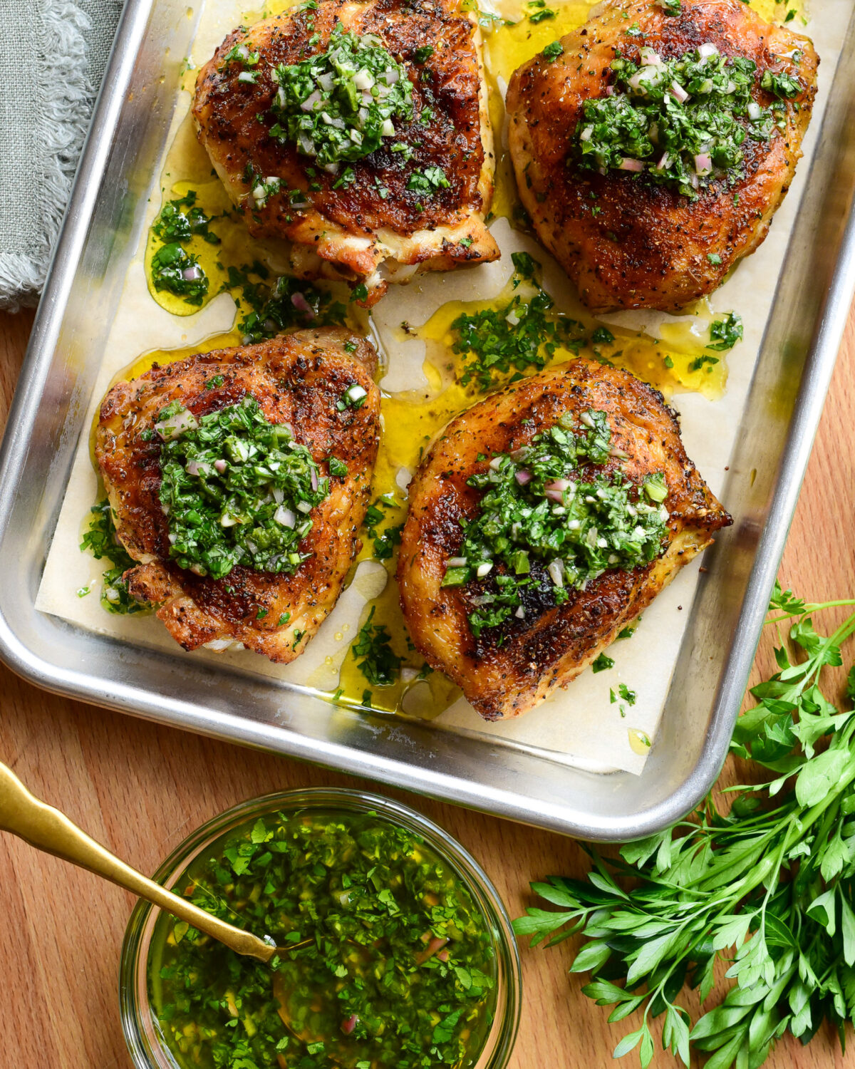 Four baked chicken thighs with chimichurri.