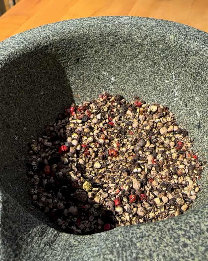 Crushed peppercorns in a mortar and pestle.