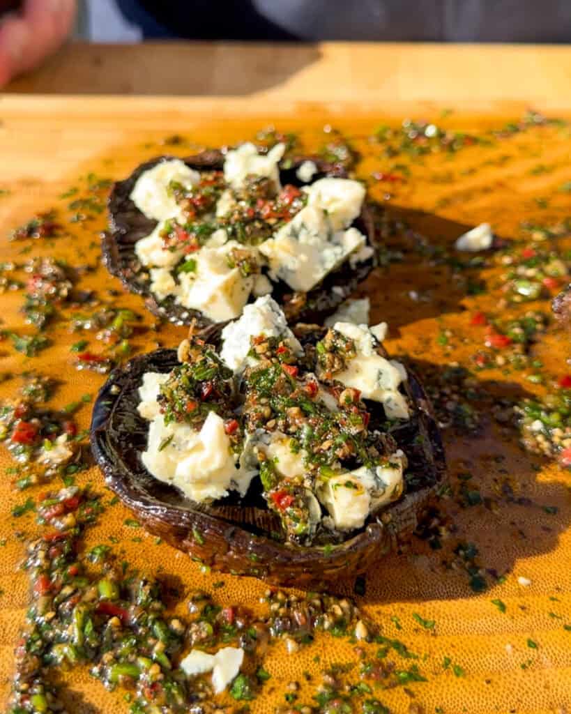 Mushrooms in board sauce with melted blue cheese.