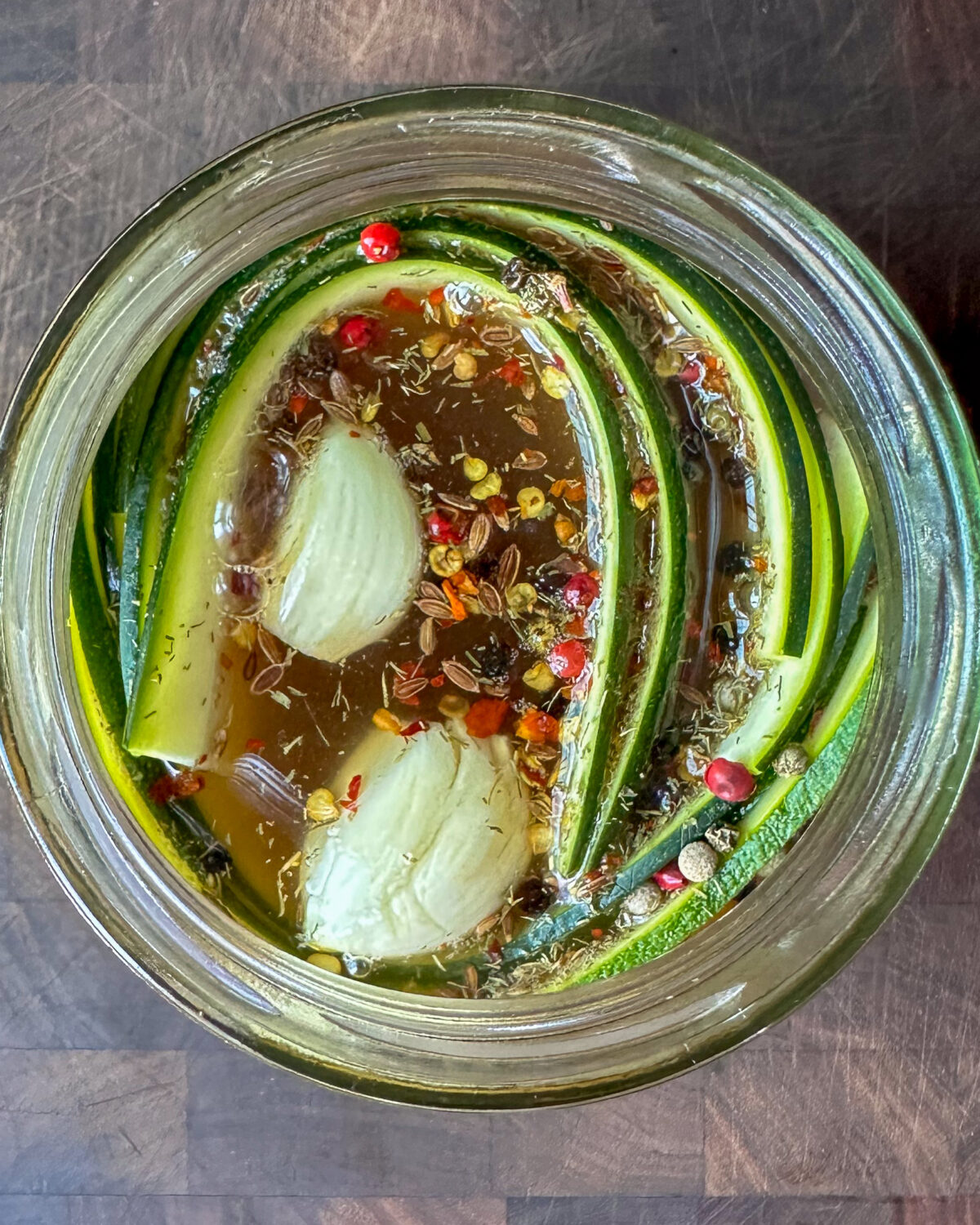 Pack zucchini and onion into the jar, wrapping the zucchini around the side of the jar and dropping the onions into the middle of the jar.