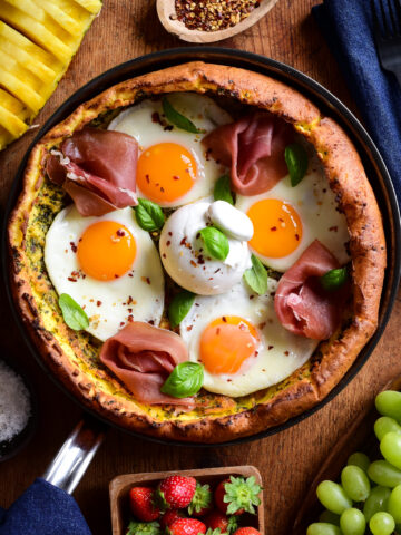 A savory Dutch baby pancake with four fried eggs, proscuitto, burratta and fresh basil.