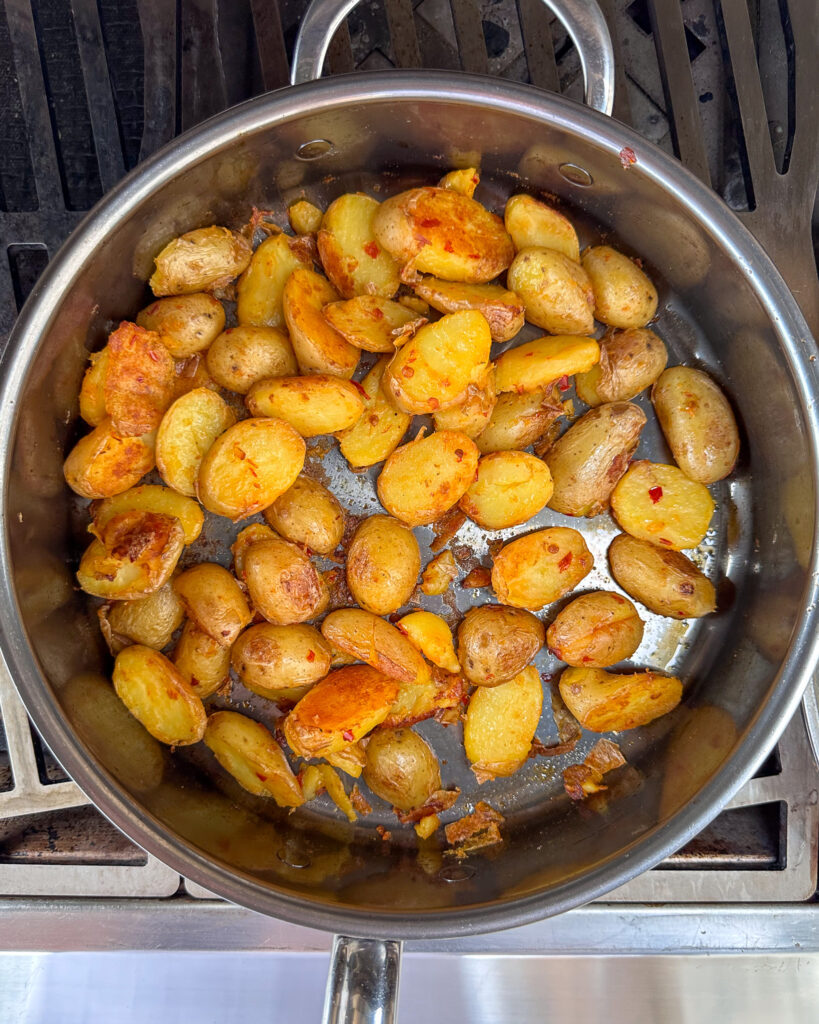 Bomba potatoe slices in a skillet.