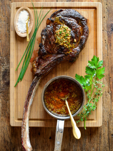 A perfectly grilled long bone ribeye with cowboy butter.