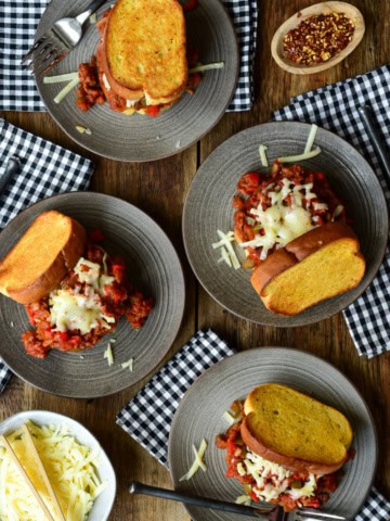 Four Weeknight Dynamite Sandwiches on plates with checkered napkins.
