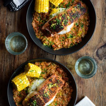 Two bowls of Blackened Salmon with a creamy Creole Sauce with rice and corn.