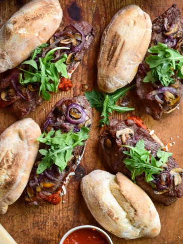 Four Grilled Veal Cutlet Sandwiches with mushrooms, onions and arugula.