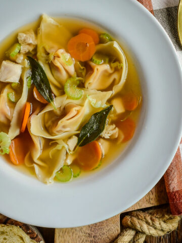 A bowl of turkey soup with squash wontons.