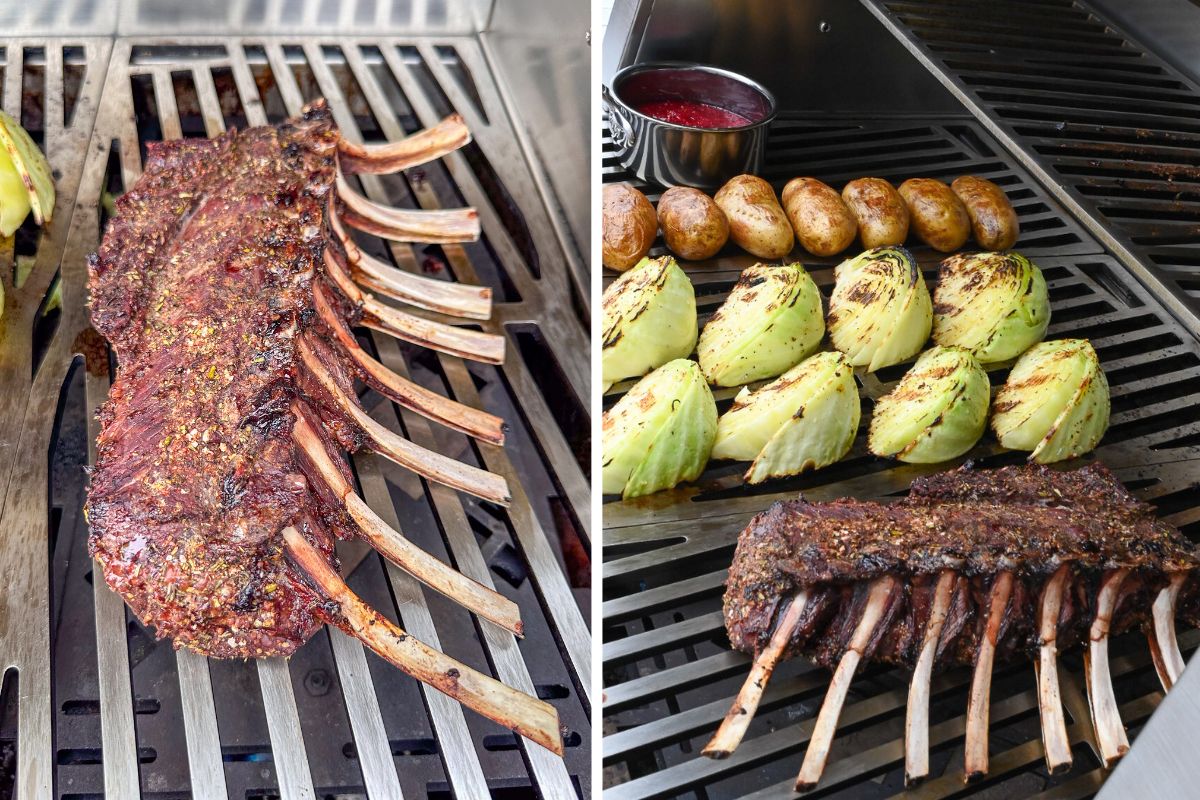 A grilled rack of venison on a grill with cabbage wedges, potatoes and a cranberry apple sauce.