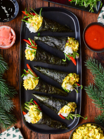 Seven Egg Salad Temaki Rolls on a platter in a festive setting.