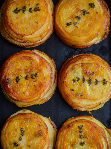 Crispy Piri-Piri Potato Stacks with a thyme sprig.