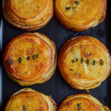 Crispy Piri-Piri Potato Stacks with a thyme sprig.