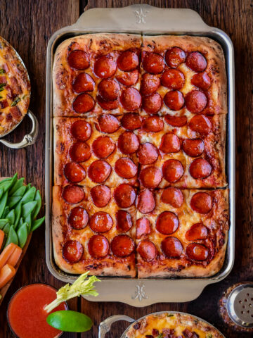 A golden, crispy pepperoni sheet pan pizza with cup and char pepperonis.