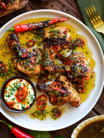 A close up of a plate of Butterflied Chicken Drumsticks with Sweet & Spicy Herb Sauce.