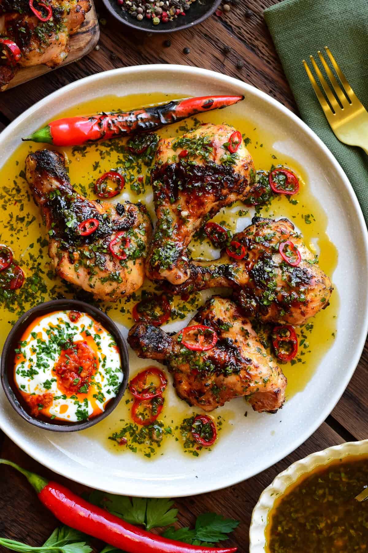 A close up of a plate of Butterflied Chicken Drumsticks with Sweet & Spicy Herb Sauce.