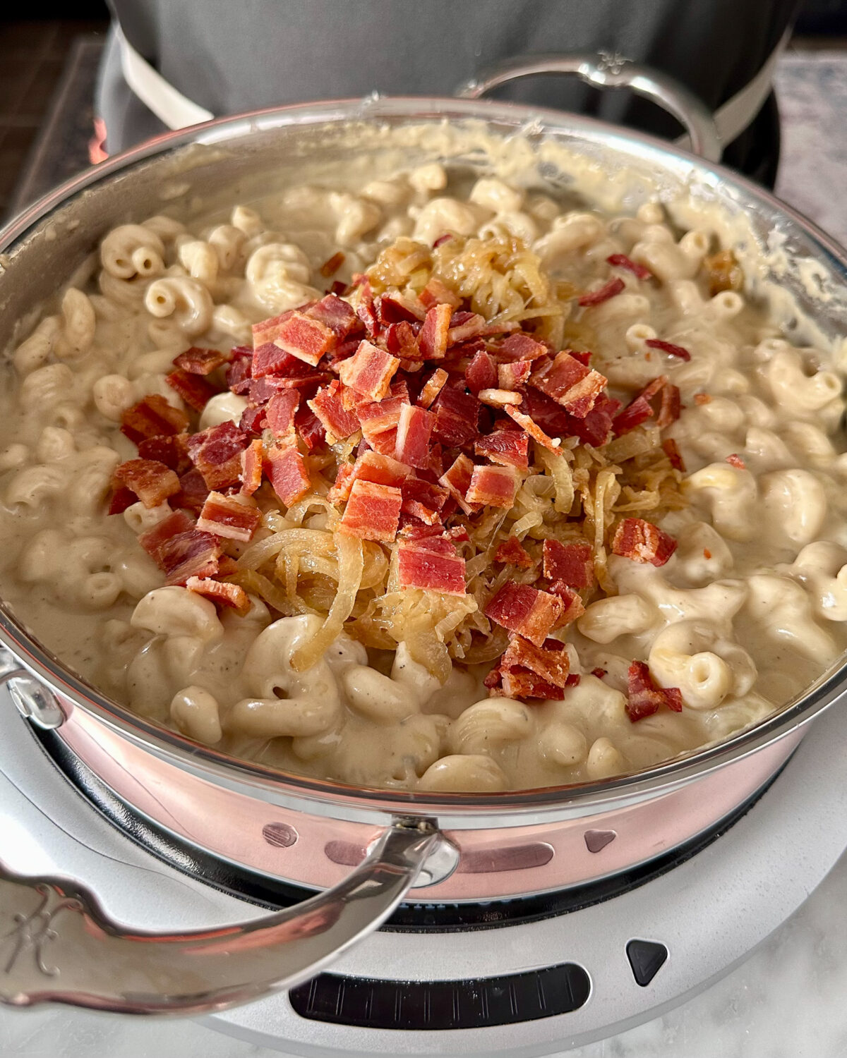 Stir cooked pasta into the cheese sauce. Fold in caramelized onions and crispy bacon.