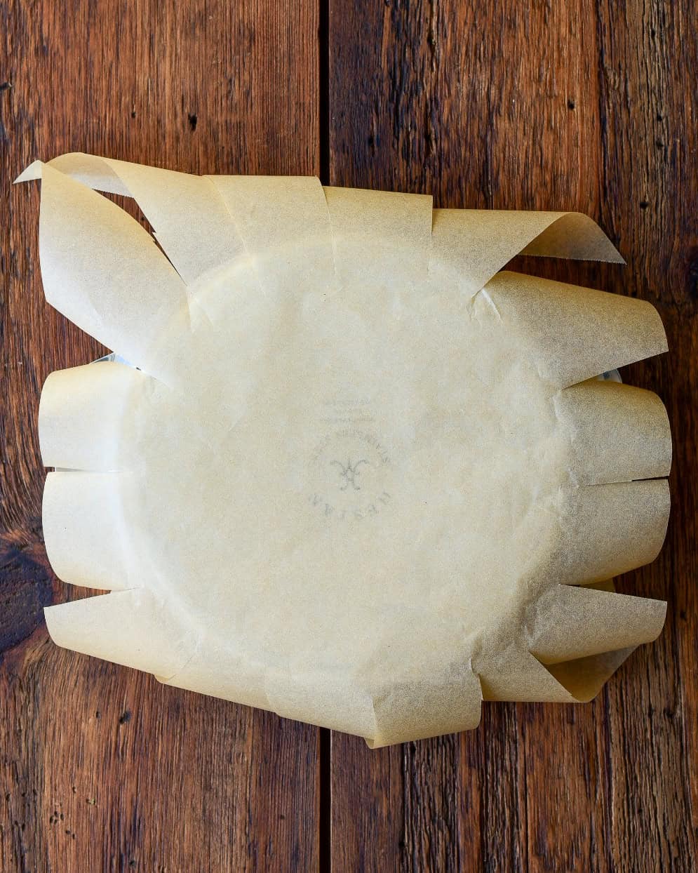 Make diagonal cuts every 2 inches from the edge of the parchment to the rim.