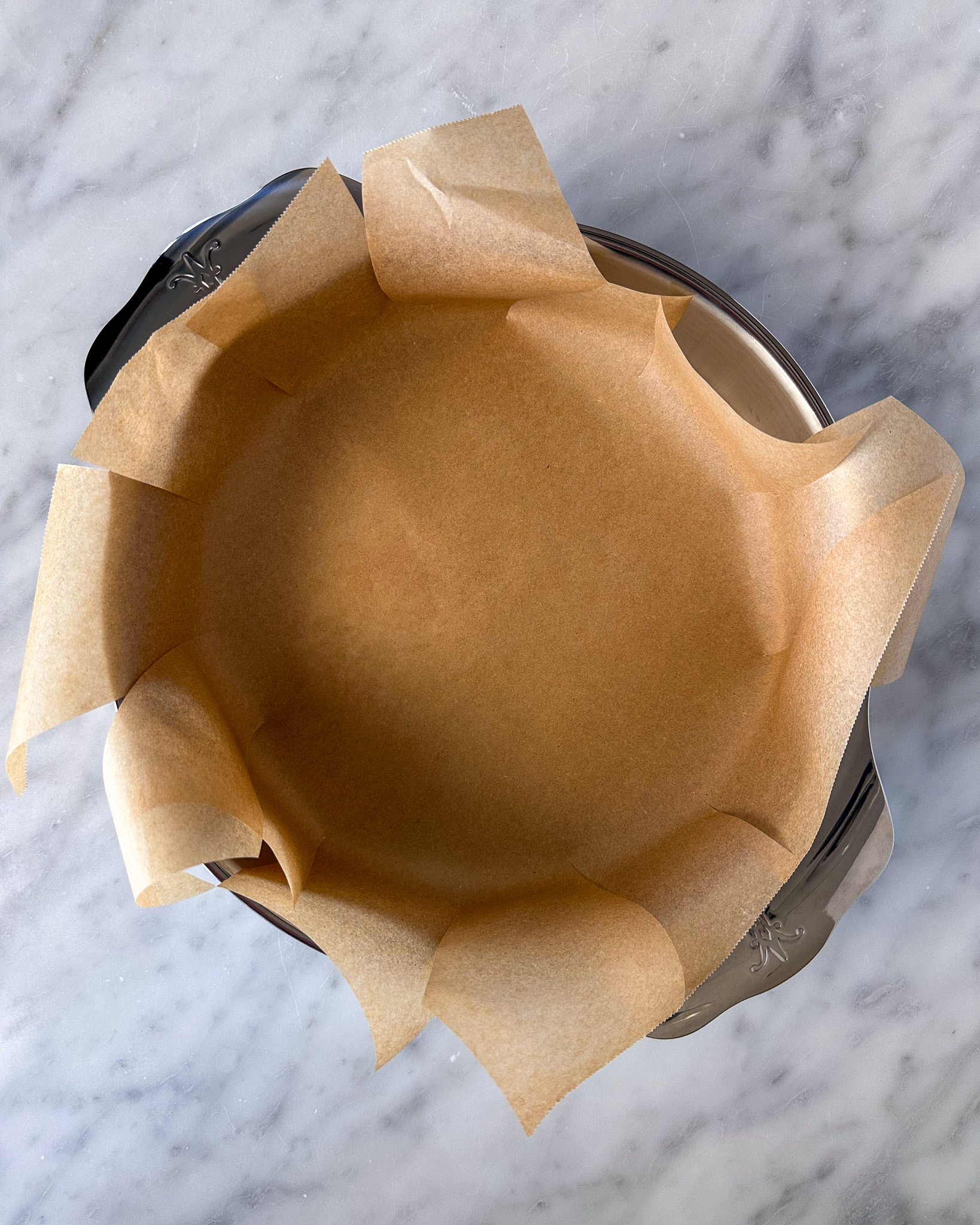 • Place the pan upright and tuck the parchment inside, ensuring it lines the bottom and sides.