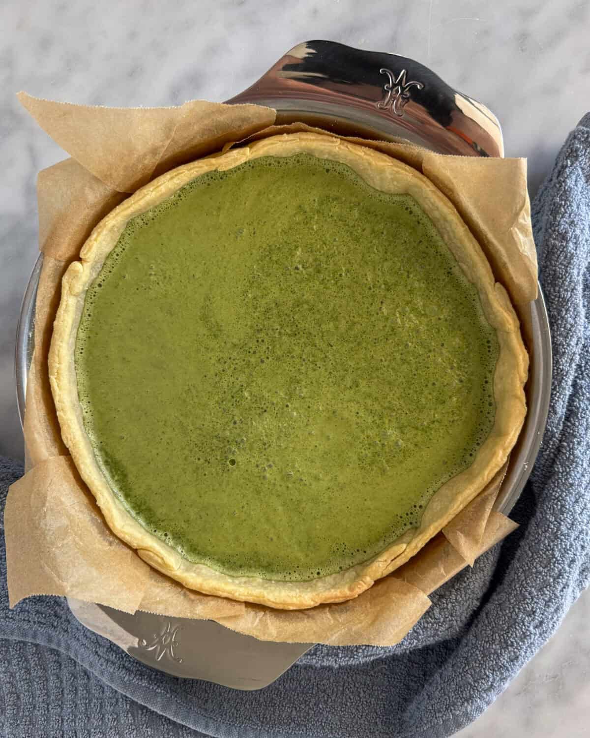 Pour the green goddess filling into the quiche.