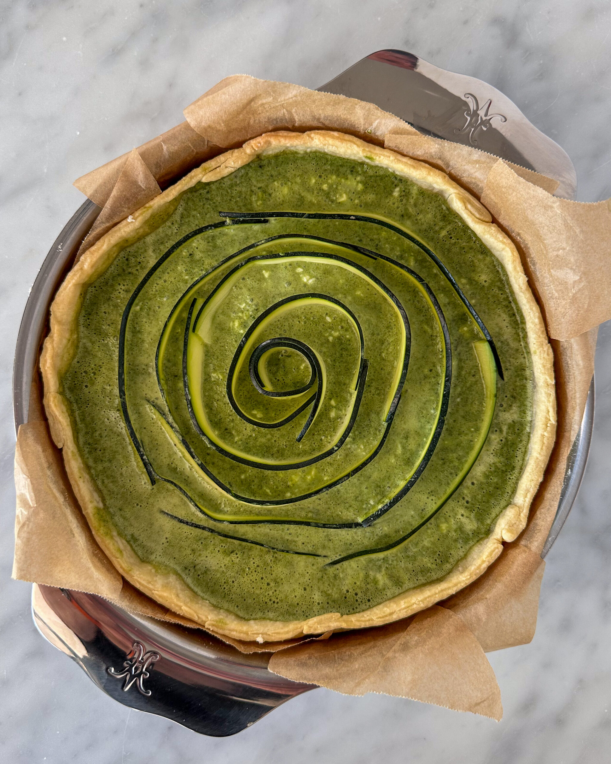 Add zucchini ribbons, starting in the centre, to form a spiral in the green quiche.