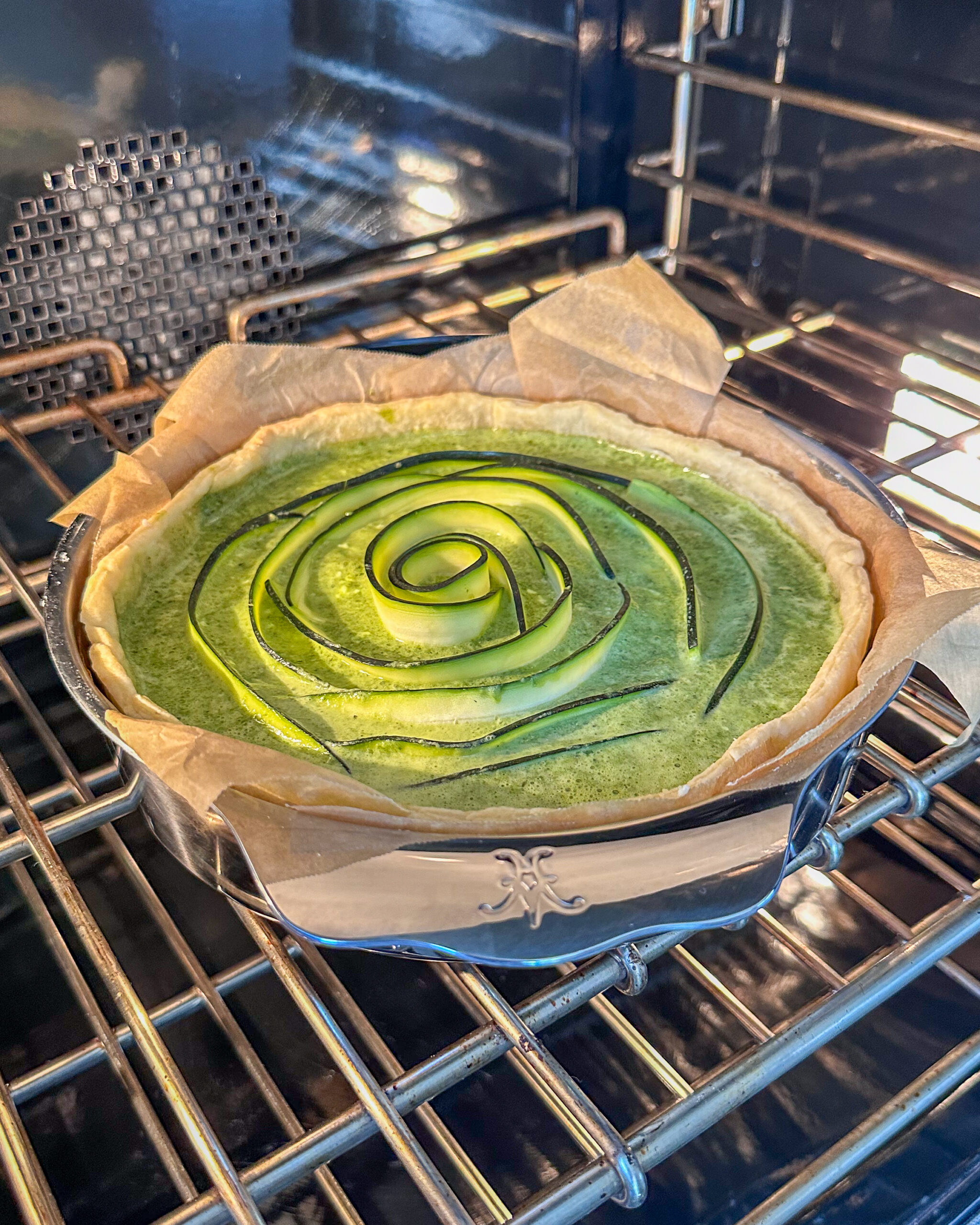 Bake the green quiche in a preheated oven at 375°F (190°C) for 35–45 minutes or until the center is set and the top is lightly golden.