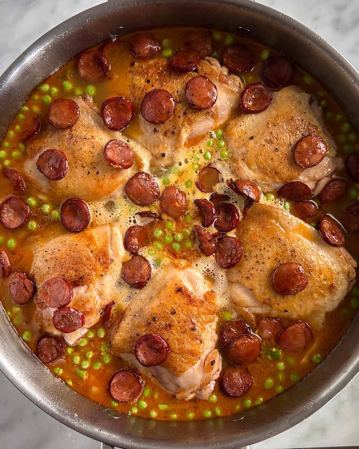 Sprinkle the chorizo over the top of the chicken and paella rice base.
