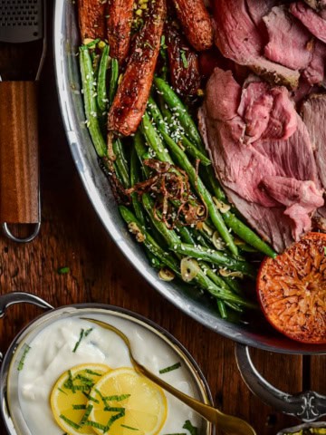 A platter with blistered green beans with lamb.