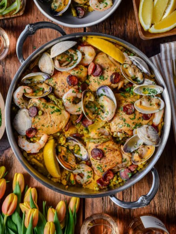 A pot of spring paella mixta with chicken, shrimp. Chorizo and clams.
