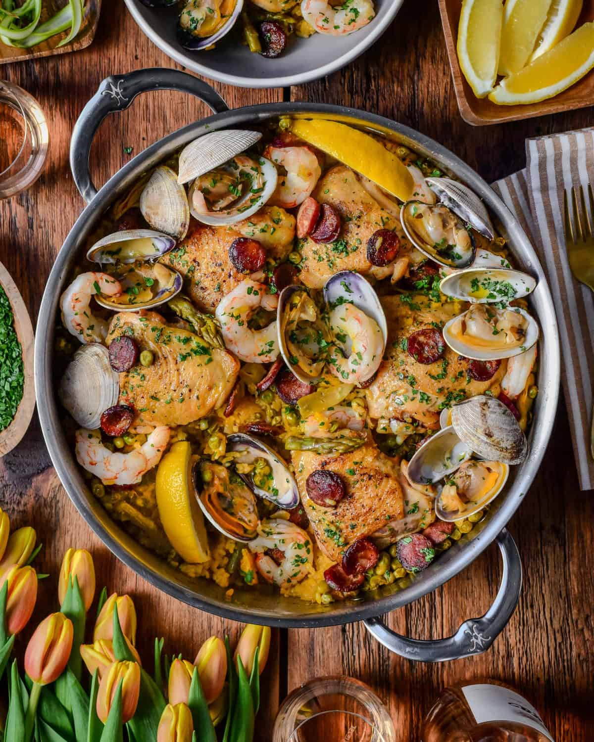 A pot of spring paella mixta with chicken, shrimp. Chorizo and clams.