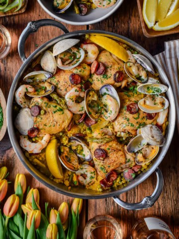A pot of spring paella mixta with chicken, shrimp. Chorizo and clams.