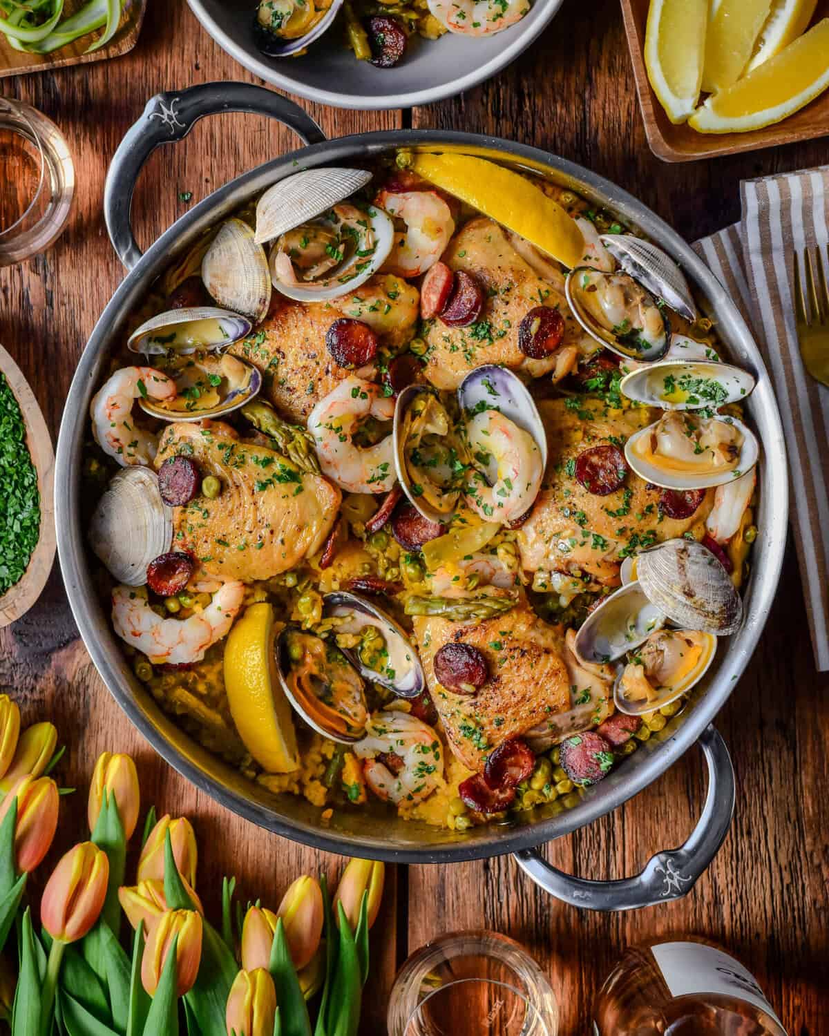 A pot of spring paella mixta with chicken, shrimp. Chorizo and clams.
