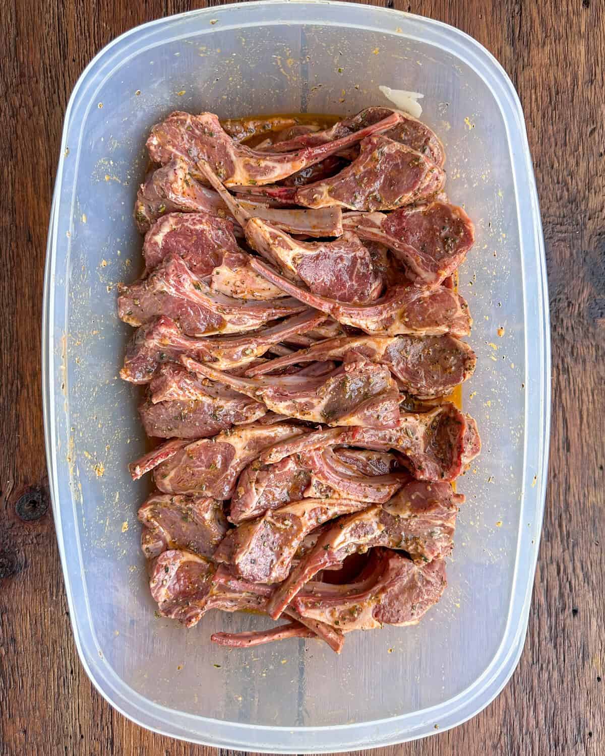 A large container with lamb covered in a Mediterranean marinade for lamb.
