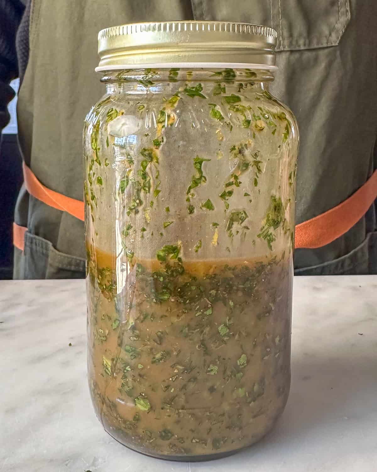 A jar with an herb board sauce for lamb.