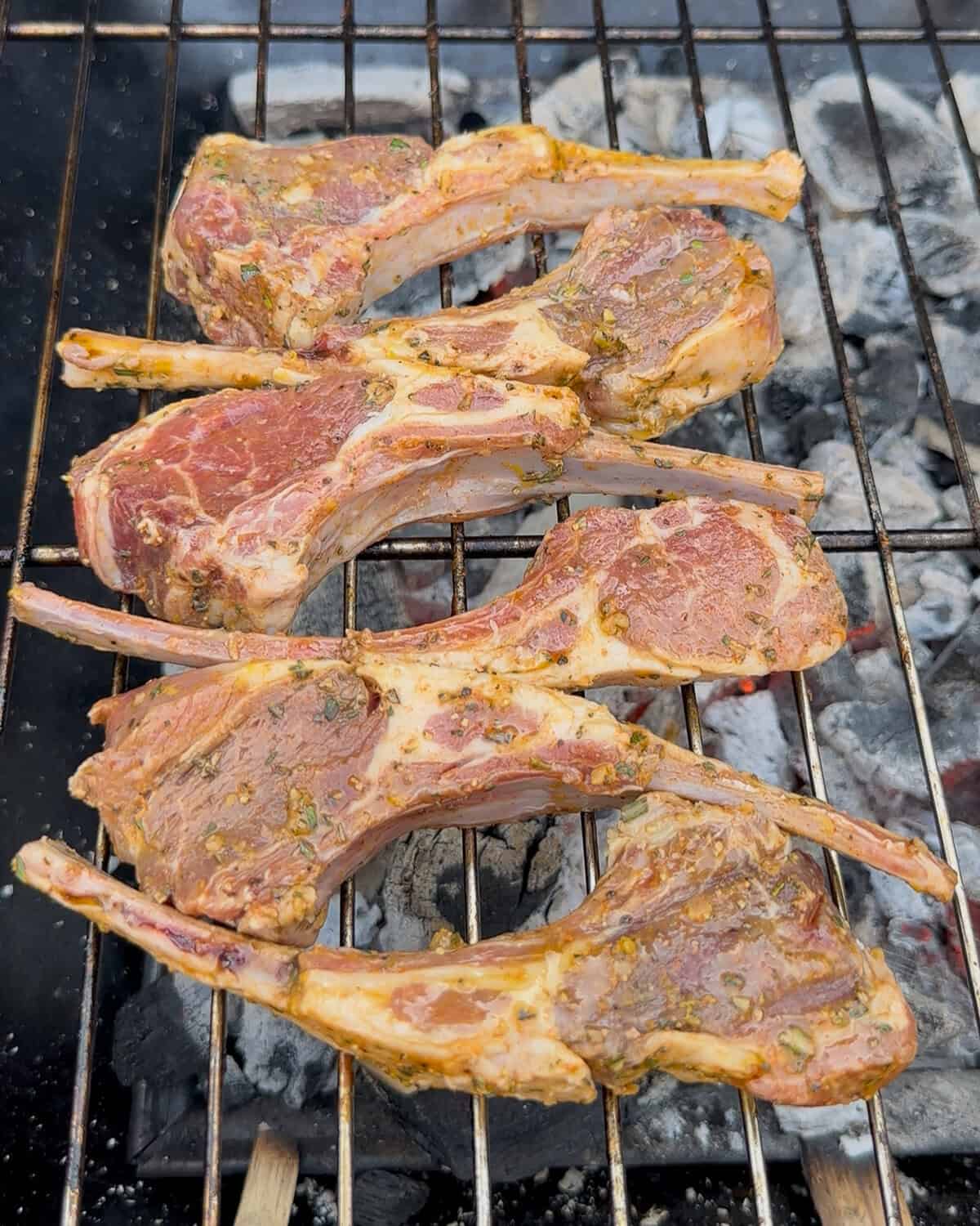 Lamb lollipops are placed on a grill.