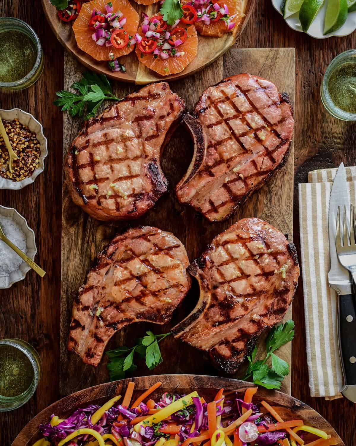 Four reverse seared pork chops served with an orange salsa and a smoky mojo red cabbage slaw.