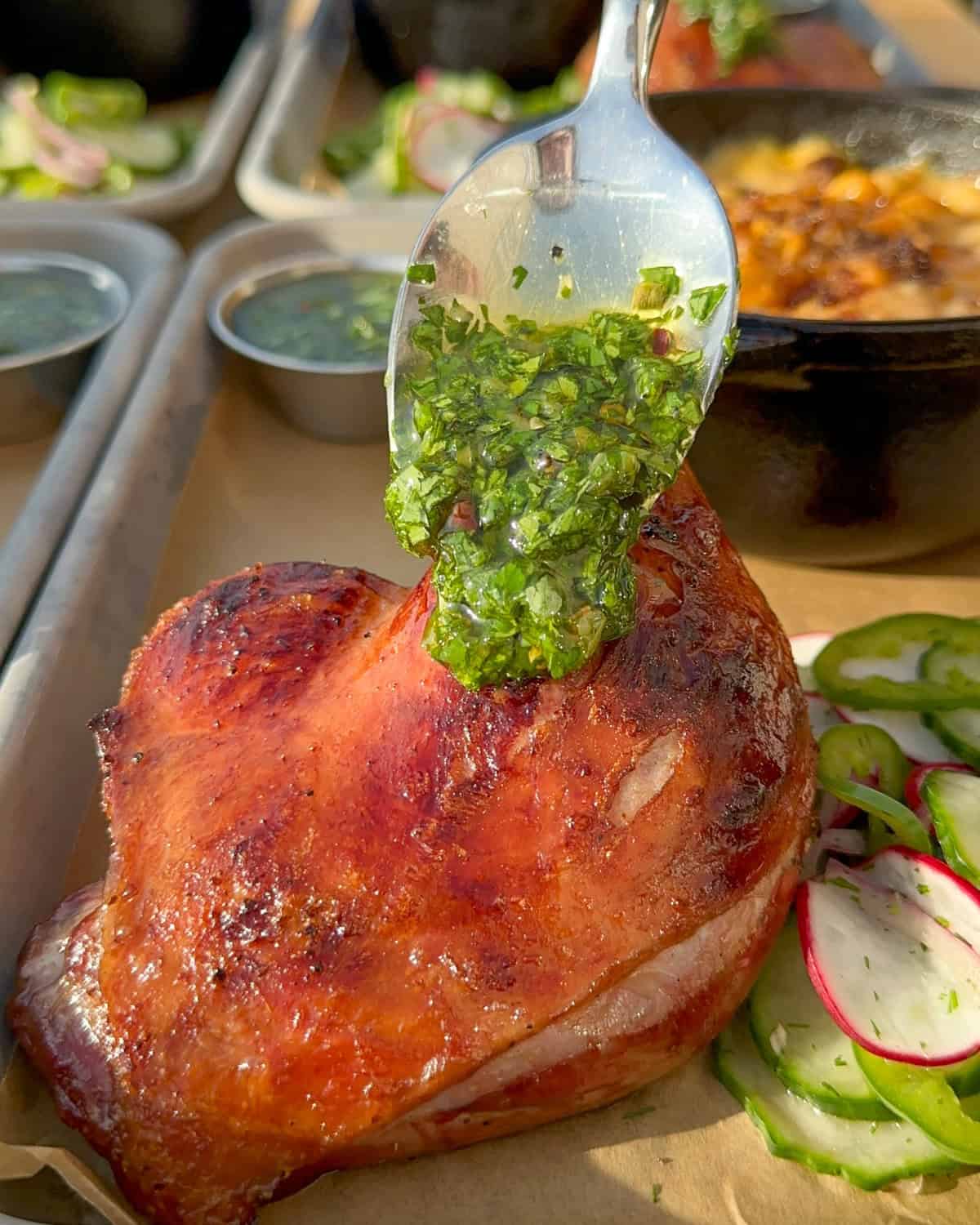 Spooning a charred scallion chimichurri over a crispy duck leg.