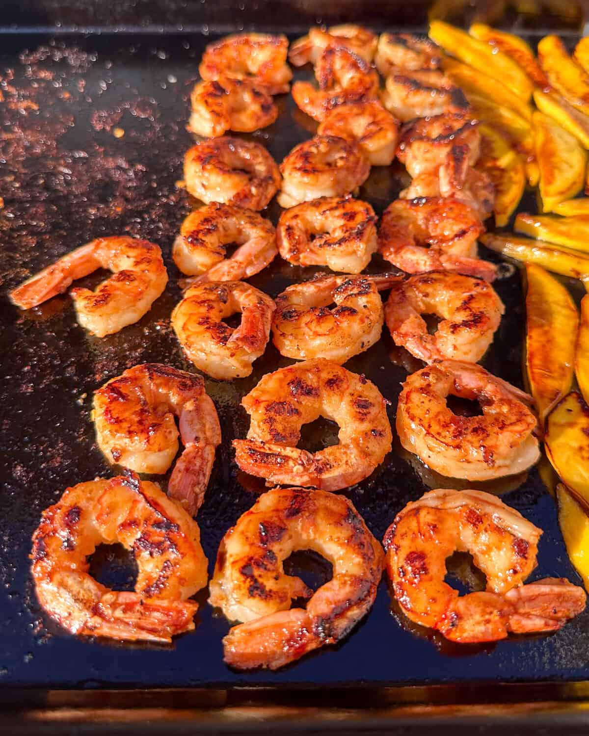 Grilled shrimp and mangos on a grill.