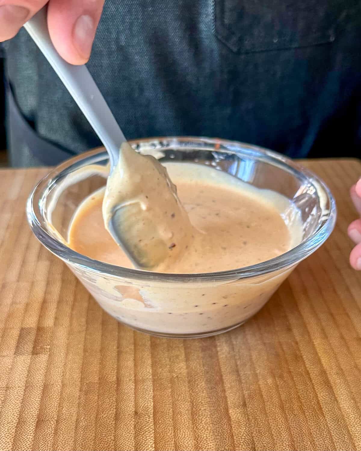Mixing a small bowl of mustard aioli.