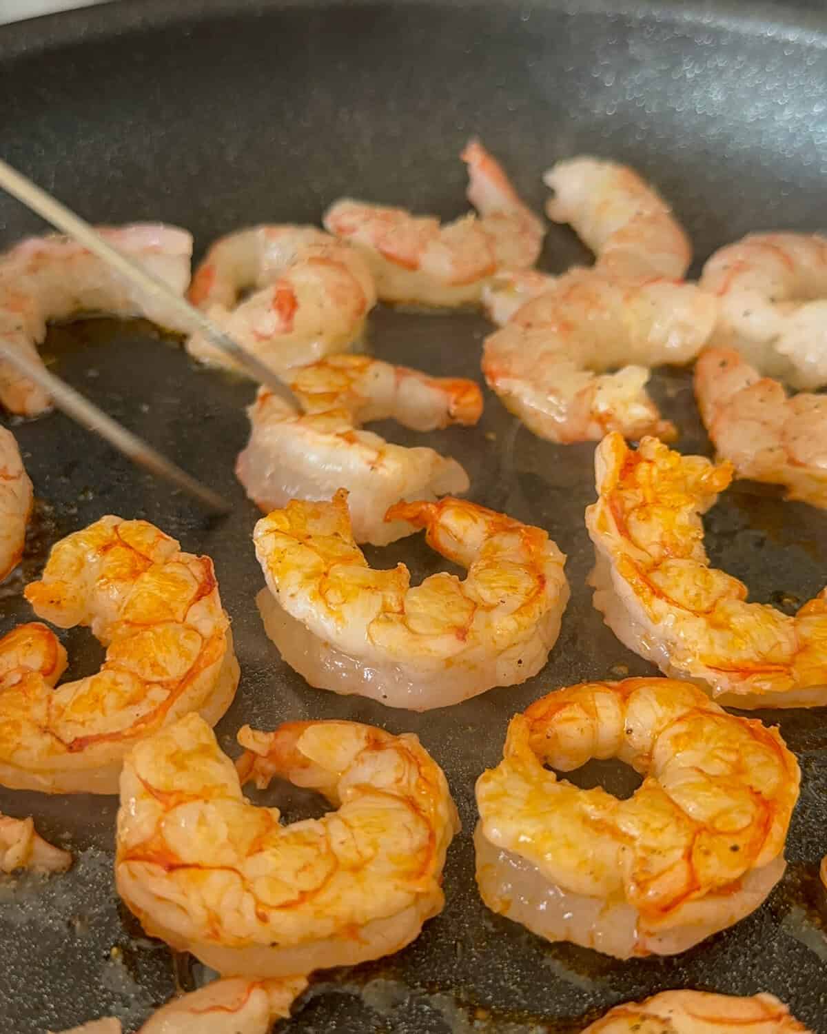 Cook the shrimp in a pan for 1-2 minutes per side.