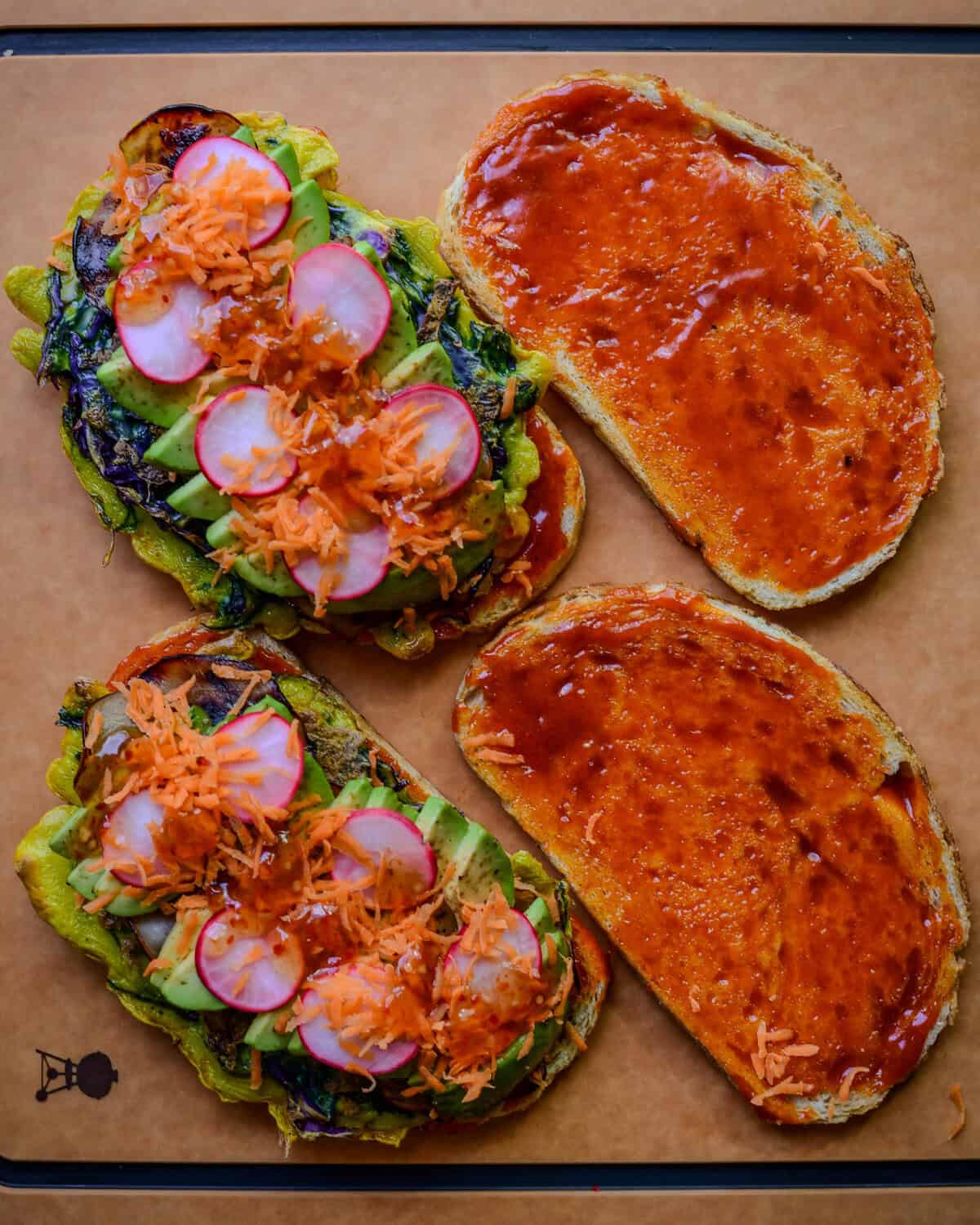 Open-faced Korean street toast with radishes, shredded carrots, gochujang mayo, egg and cabbage omelette, Mayak avocado and grilled ham.