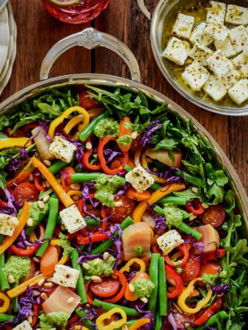 A Warm Rainbow Veggie Salad served with Fresh Summer Pesto and marinated feta cheese.