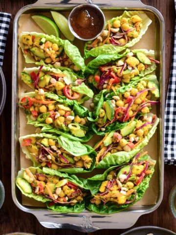 Two rows of five Curried Coconut Chickpea and Mango Salad wraps on a tray.