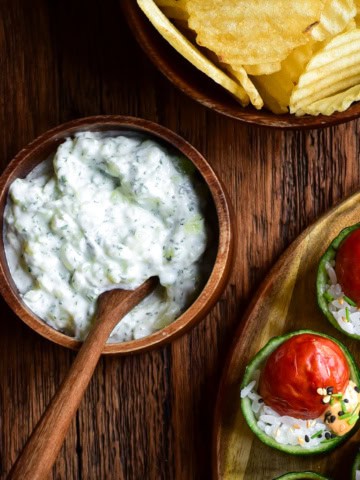A bowl of an Easy Cucumber Mint Yogurt Dip (Zero Waste Recipe) served with ruffled chips and cucumber cups.